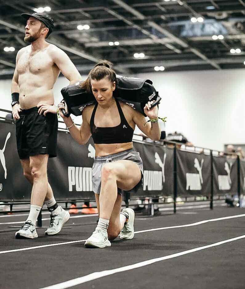 Athlete performing sandbag lunges during the Hyrox London event.